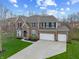 Stately brick home with a large driveway, manicured lawn, and an attached two-car garage at 6711 Colville Pl, Indianapolis, IN 46236