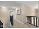 Upstairs hallway with neutral carpeting and dark wood railing at 6711 Colville Pl, Indianapolis, IN 46236