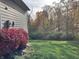 Landscaped yard with red shrubs and wooded backdrop at 6711 Colville Pl, Indianapolis, IN 46236