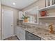 Modern kitchen with white cabinets, stainless steel sink, and pass-through window at 6731 W 15Th St, Indianapolis, IN 46214