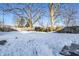 Snowy backyard with a wooden fence and mature trees at 857 S Tompkins St, Shelbyville, IN 46176