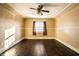 Empty bedroom with hardwood floors, ceiling fan, and window with curtains at 857 S Tompkins St, Shelbyville, IN 46176