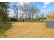 An expansive backyard featuring mature trees, a fenced perimeter, and a shed at 8810 W Tulip Tree Dr, Muncie, IN 47304