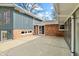 Back of home, patio area, and sunroom with large sliding glass door and brick exterior at 8810 W Tulip Tree Dr, Muncie, IN 47304