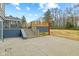 A backyard featuring a concrete patio, a wooden deck with stairs, and a sunroom addition at 8810 W Tulip Tree Dr, Muncie, IN 47304