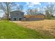 An expansive backyard featuring green grass, mature trees, a deck, and a sunroom addition at 8810 W Tulip Tree Dr, Muncie, IN 47304