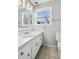 Clean bathroom with single vanity, updated tile, and a large window at 8810 W Tulip Tree Dr, Muncie, IN 47304