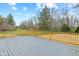Wooden deck with railing overlooking yard with mature trees and surrounding greenery at 8810 W Tulip Tree Dr, Muncie, IN 47304