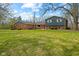 Charming brick home with blue siding, a bright red front door, and a spacious front lawn at 8810 W Tulip Tree Dr, Muncie, IN 47304