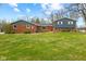 View of home with brick and siding, trimmed bushes in front, and green lawn at 8810 W Tulip Tree Dr, Muncie, IN 47304