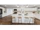 White kitchen with large island, stainless steel appliances, and herringbone tile backsplash at 8810 W Tulip Tree Dr, Muncie, IN 47304