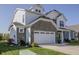 Angle shot of a two-story house with a two-car garage, stone facade, white siding, and a well-kept green lawn at 1001 Parker Ln, Westfield, IN 46074