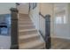 Carpeted staircase with dark wood railing and decorative accents leads to the upper level at 1001 Parker Ln, Westfield, IN 46074