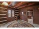 Charming living room with log cabin details, a round rug, and access to the kitchen at 1084 Chipmunk Ln, Pendleton, IN 46064
