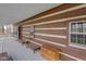 Long covered porch showcasing log cabin exterior at 1084 Chipmunk Ln, Pendleton, IN 46064