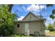 Backside of home featuring an exterior door, small stairs, and utility access in a private, verdant setting at 1128 N Holmes Ave, Indianapolis, IN 46222