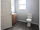Clean bathroom with light wood vanity and dark vinyl flooring at 1128 N Holmes Ave, Indianapolis, IN 46222