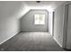 Bright bedroom featuring grey carpeting, a window, and sloped ceilings at 1128 N Holmes Ave, Indianapolis, IN 46222