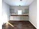 Simple kitchen featuring gray cabinets and dark wood flooring at 1128 N Holmes Ave, Indianapolis, IN 46222