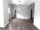 Living room with grey walls, dark grey vinyl flooring, and staircase at 1128 N Holmes Ave, Indianapolis, IN 46222