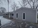 Side view of gray vinyl-sided ranch home in snowy landscape at 117 Tracy Rd, Whiteland, IN 46184