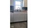 Simple white kitchen with a farmhouse sink and vinyl flooring at 135 S 11Th Ave, Beech Grove, IN 46107