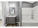 Updated bathroom with gray walls, wood-look floors, vanity, and shower/tub combo at 1418 S New Jersey St, Indianapolis, IN 46225