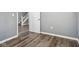 Simple bedroom with gray walls, wood-look floors, and a view of a staircase at 1418 S New Jersey St, Indianapolis, IN 46225