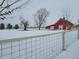 Red barn and snowy landscape with trees and fence at 1545 S Us 421, Zionsville, IN 46077