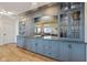 Bar area featuring custom blue cabinetry, granite countertop, dual sinks and mirrored backsplash at 15844 Nocturne Dr, Westfield, IN 46074