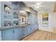 Bar area featuring custom blue cabinetry, granite countertop, dual sinks and mirrored backsplash at 15844 Nocturne Dr, Westfield, IN 46074