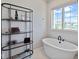 Bright bathroom with a sleek standalone tub and decorative shelving unit for a modern aesthetic at 15844 Nocturne Dr, Westfield, IN 46074