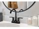 Modern bathroom sink with matte black faucet, round mirror, and stylish countertop at 15844 Nocturne Dr, Westfield, IN 46074