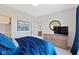 Comfortable bedroom with blue bedding, a wooden dresser with television, and a decorative round mirror at 15844 Nocturne Dr, Westfield, IN 46074