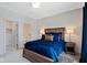 Well-lit bedroom with a wooden bed frame, stylish blue bedding, bedside tables, and an attached bathroom at 15844 Nocturne Dr, Westfield, IN 46074