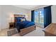 Cozy bedroom showcasing a wooden bed frame, blue bedding, bedside tables, and a view of the neighborhood at 15844 Nocturne Dr, Westfield, IN 46074