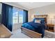 Bedroom with a large window, blue curtains, and a comfortable bed with stylish bedding and bedside tables at 15844 Nocturne Dr, Westfield, IN 46074