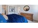 Bright bedroom featuring a large bed with stylish blue bedding and a round mirror over a wooden dresser at 15844 Nocturne Dr, Westfield, IN 46074
