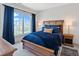 Comfortable bedroom featuring a wooden bed frame with blue bedding, bedside tables, and neighborhood view at 15844 Nocturne Dr, Westfield, IN 46074