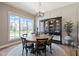 Bright dining area with a wooden table, black chairs, and a large window overlooking the yard at 15844 Nocturne Dr, Westfield, IN 46074
