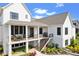 Rear exterior elevation showcasing covered patio, deck, stone accents, and landscaped yard at 15844 Nocturne Dr, Westfield, IN 46074