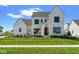 Beautiful white brick two-story home with a well manicured lawn and a covered front entry at 15844 Nocturne Dr, Westfield, IN 46074