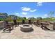 Outdoor fire pit area with stone pavers, seat wall and Adirondack chairs overlooking a scenic view at 15844 Nocturne Dr, Westfield, IN 46074