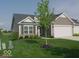 Inviting single-story home with an attached garage, landscaped front yard, and a blend of siding and stone at 173 Megan Way, Cumberland, IN 46229