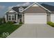 Well-maintained single-story home featuring an attached garage, manicured lawn, and inviting front entrance at 173 Megan Way, Cumberland, IN 46229