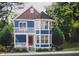 Two-story blue house with wrap-around porch and bay window at 1831 Luther St, Indianapolis, IN 46203