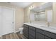 This bathroom has a double sink vanity, toilet, vinyl flooring, and a large mirror at 1833 Luther St, Indianapolis, IN 46203