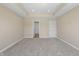 Spacious bedroom features neutral carpet, tray ceiling, and a doorway with a view to another room at 1833 Luther St, Indianapolis, IN 46203