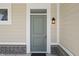 Modern gray front door with sidelight and overhead window, brick accents and a lantern fixture at 1833 Luther St, Indianapolis, IN 46203