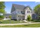 Charming two-story home with a manicured lawn, gray siding and a quaint covered front porch at 1833 Luther St, Indianapolis, IN 46203